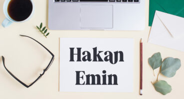 overhead-view-laptop-with-stationeries-tea-cup-colored-backdrop